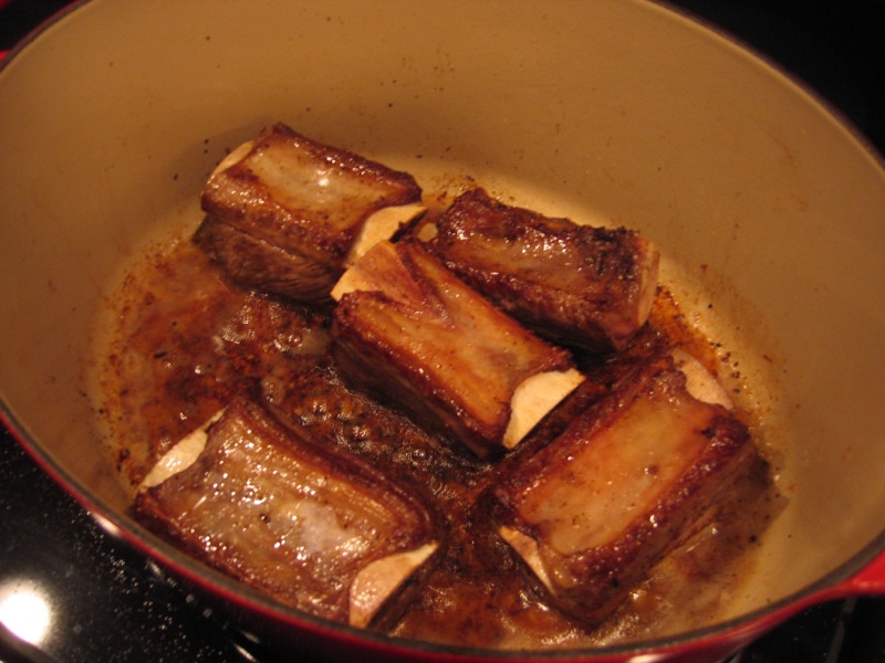 Bone-in beef short ribs seared dark brown in the same pot.